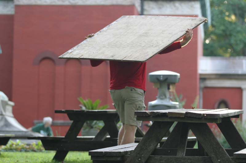 a man holding a large piece of wood over his head