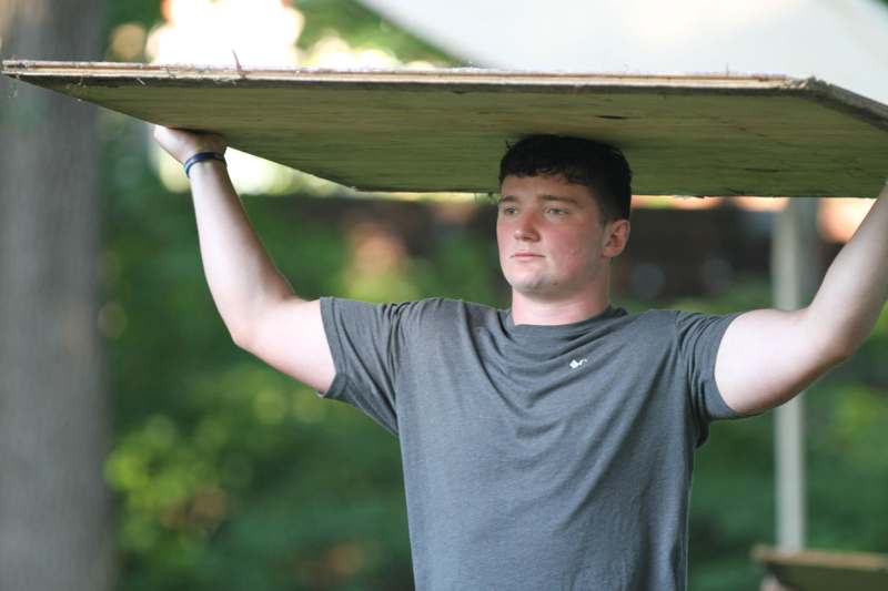 a man holding a wood board over his head