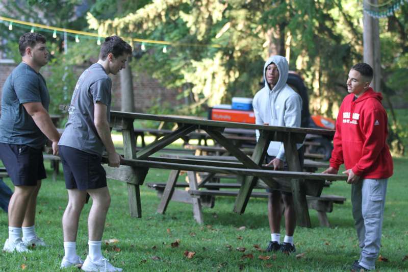 a group of people holding a picnic table
