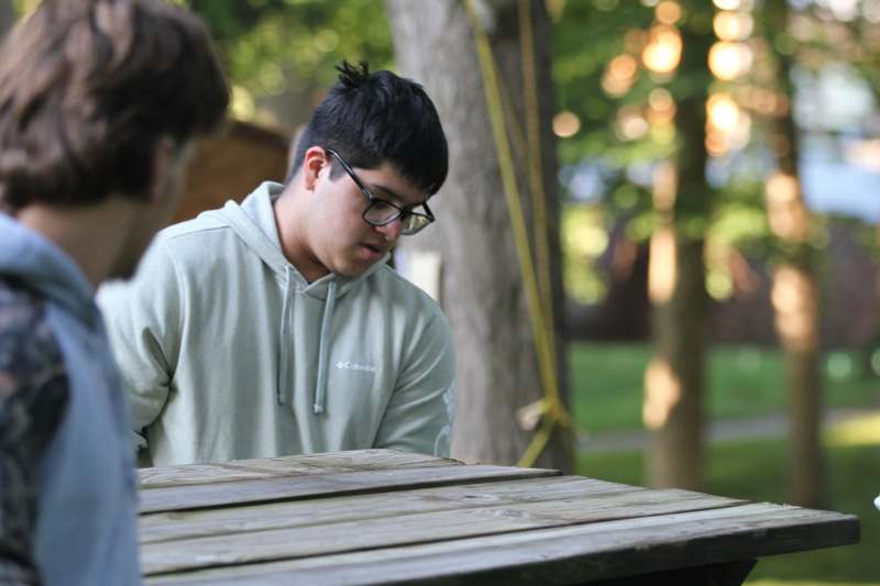 a man standing next to a wooden table
