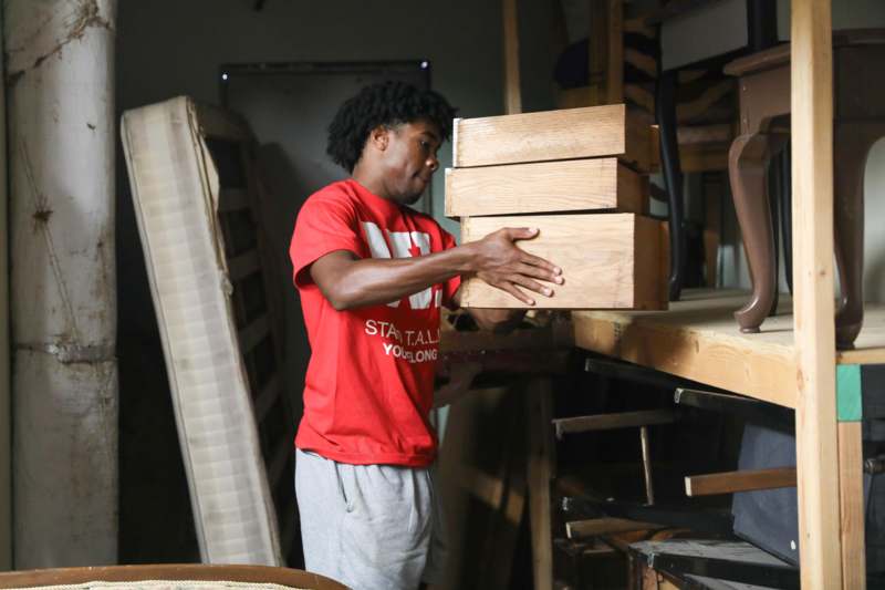 a man holding a stack of wood