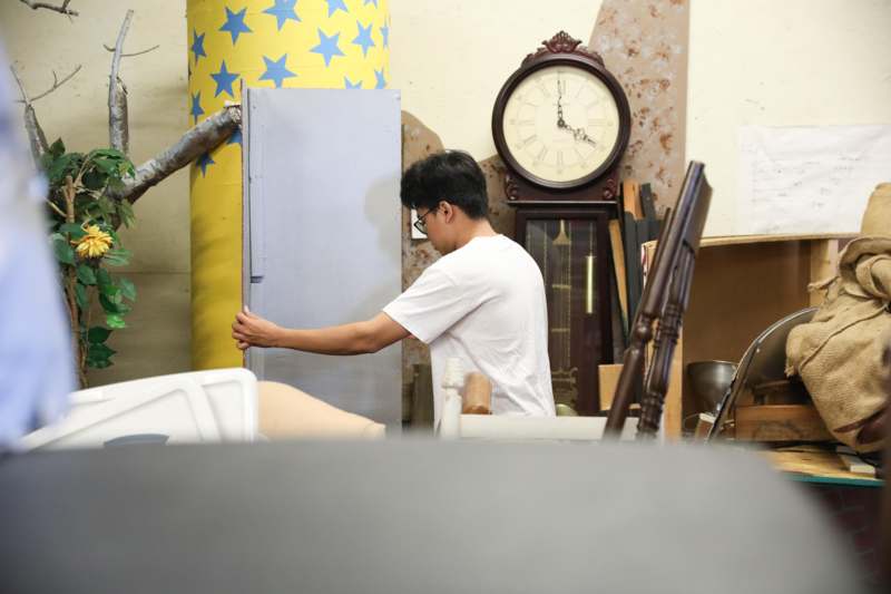 a man holding a blue cabinet