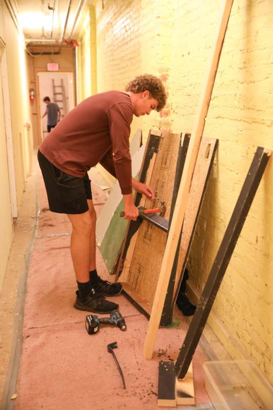 a man holding a hammer and a piece of wood