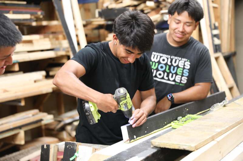 a man using a drill to drill a piece of wood