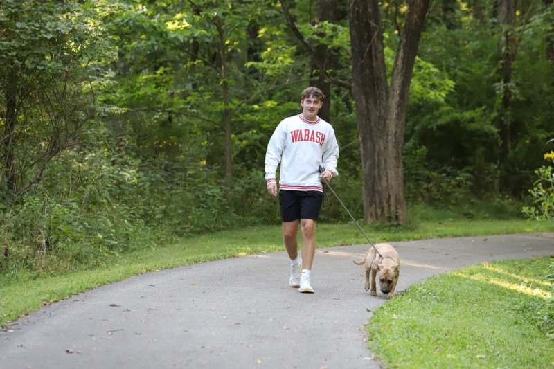 a man walking a dog on a path