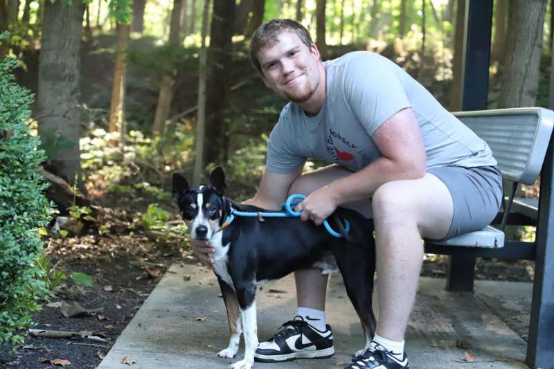 a man sitting on a bench with a dog