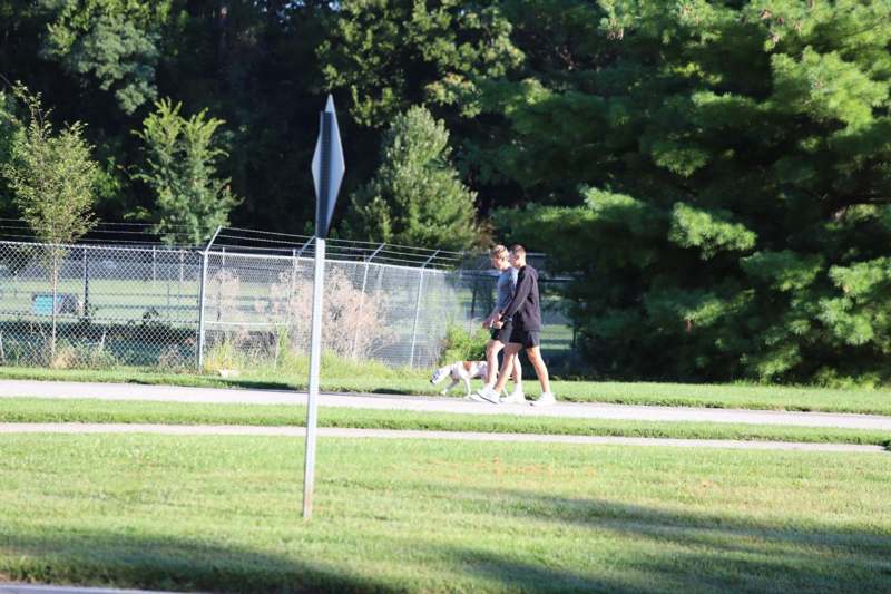 two people walking a dog