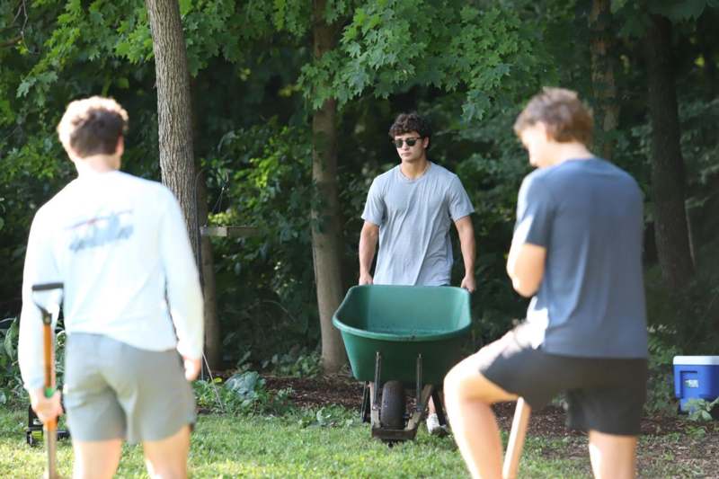 a group of people outside with a wheelbarrow