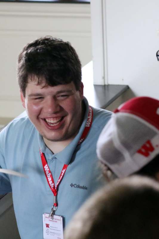 a man laughing with a red lanyard