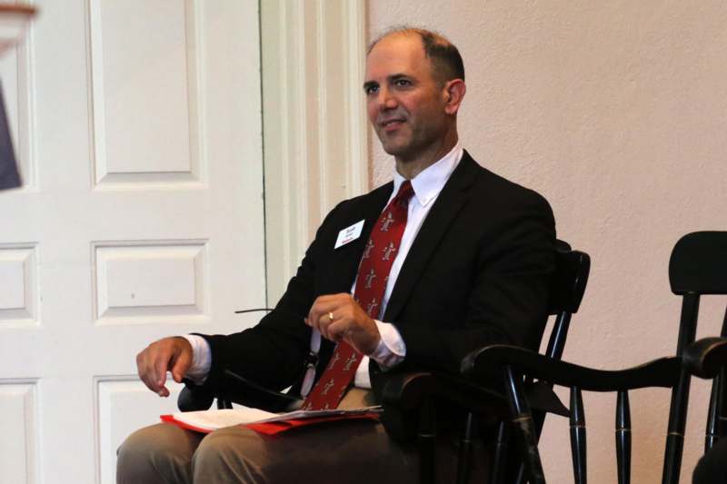 a man in a suit and tie sitting in a chair