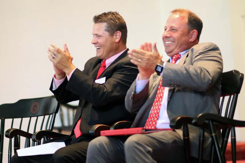 a group of men in suits and ties clapping