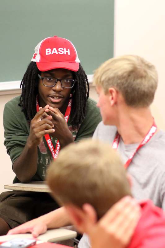 a man wearing a red hat and a red and white cap talking to another man