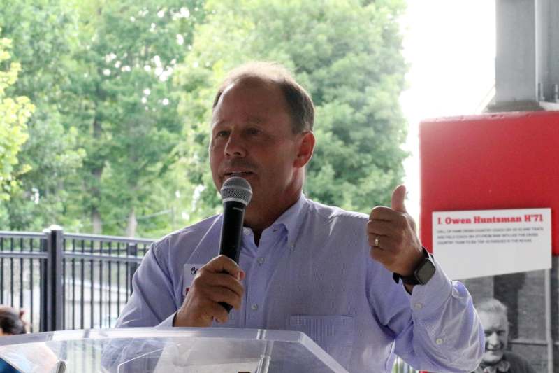 a man holding a microphone and giving a thumbs up