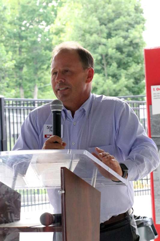 a man standing at a podium speaking into a microphone
