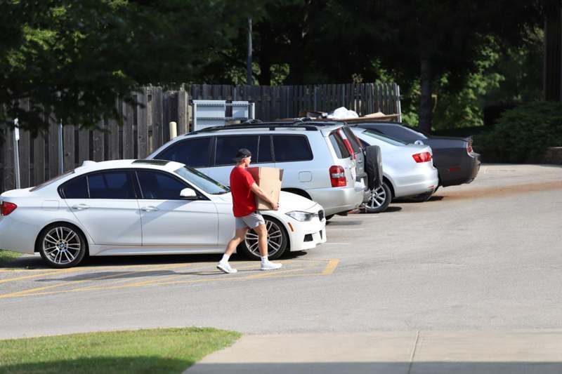 a man walking with a box in his hand