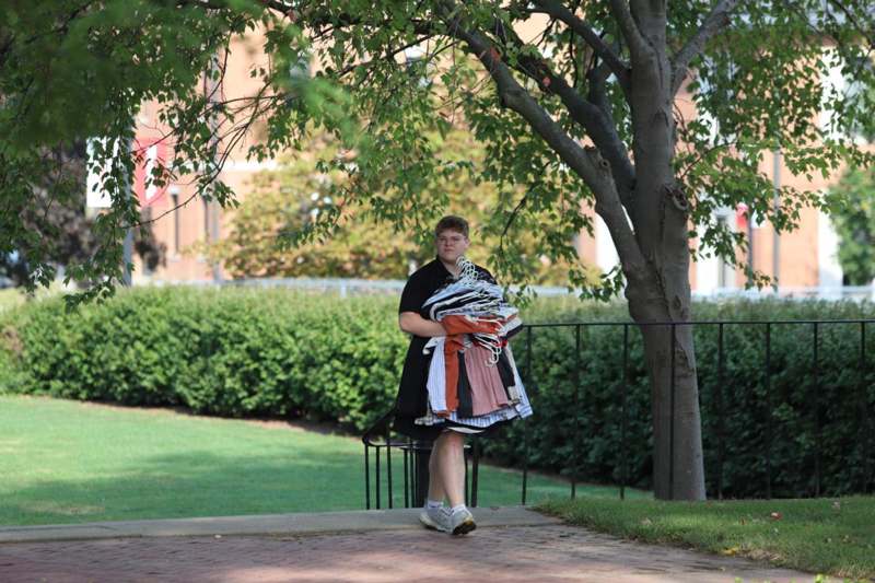 a man holding a pile of clothes