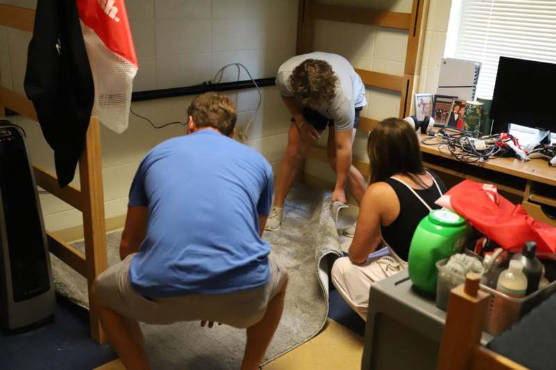 a group of people folding a carpet