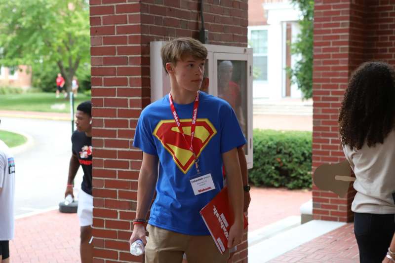 a boy wearing a blue shirt and a red book