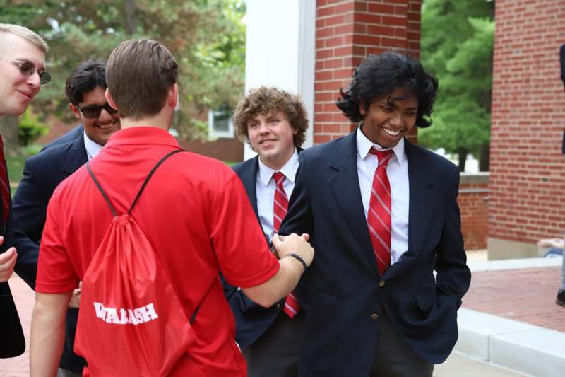 a group of men shaking hands outside a building