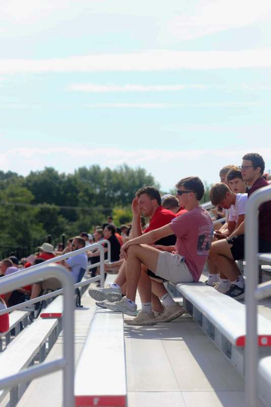 a group of people sitting on bleachers