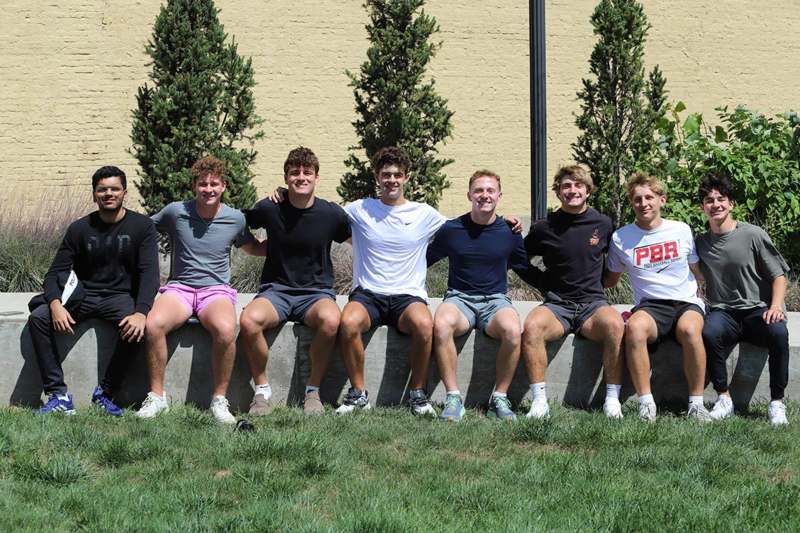 a group of people sitting on a wall