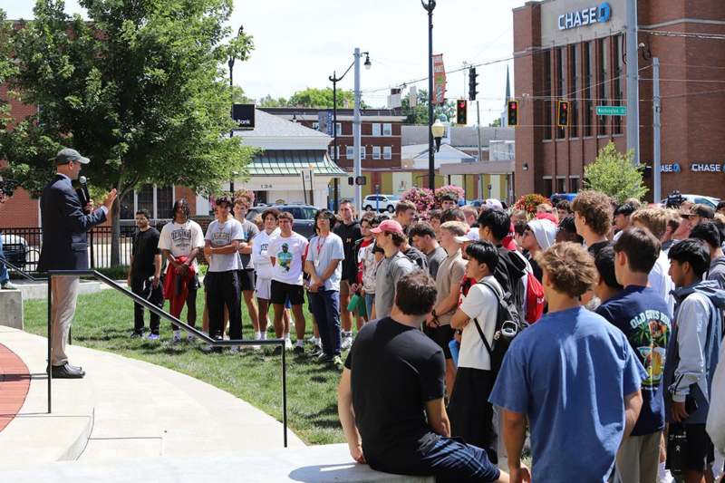 a group of people standing on a sidewalk