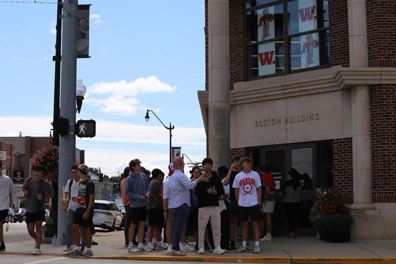 a group of people standing on the sidewalk