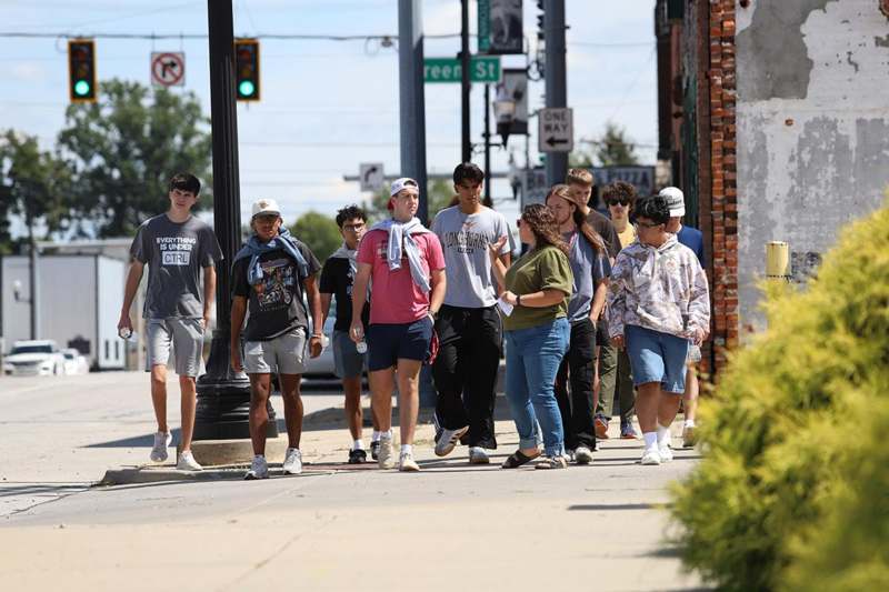 a group of people walking on a sidewalk