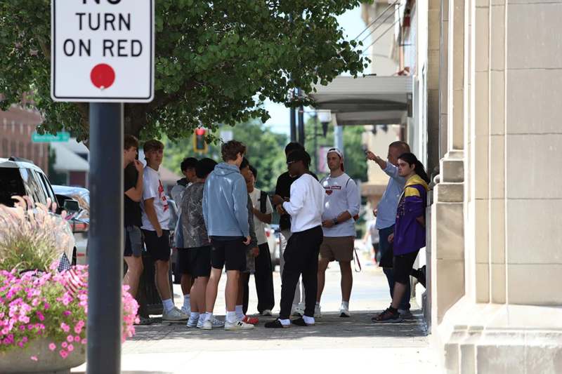 a group of people standing on a sidewalk