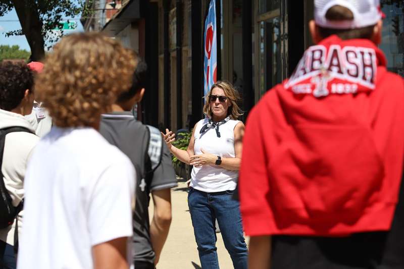 a woman standing on a sidewalk with other people