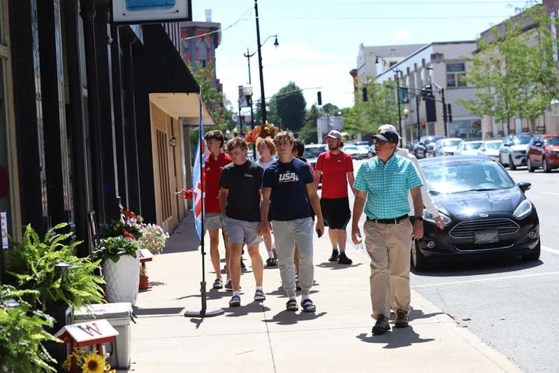 a group of people walking on a sidewalk