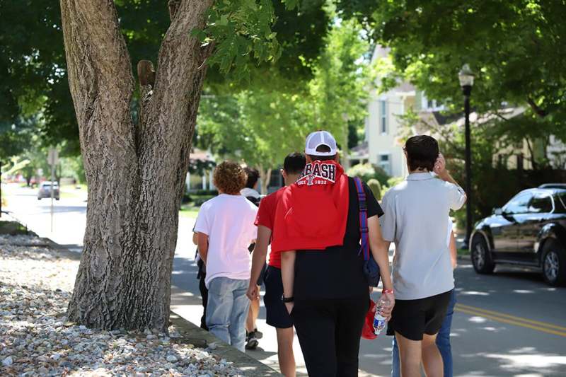 a group of people walking on a sidewalk