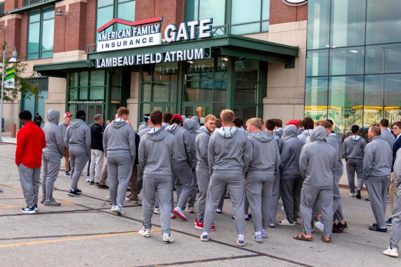 a group of people in grey tracksuits outside a building