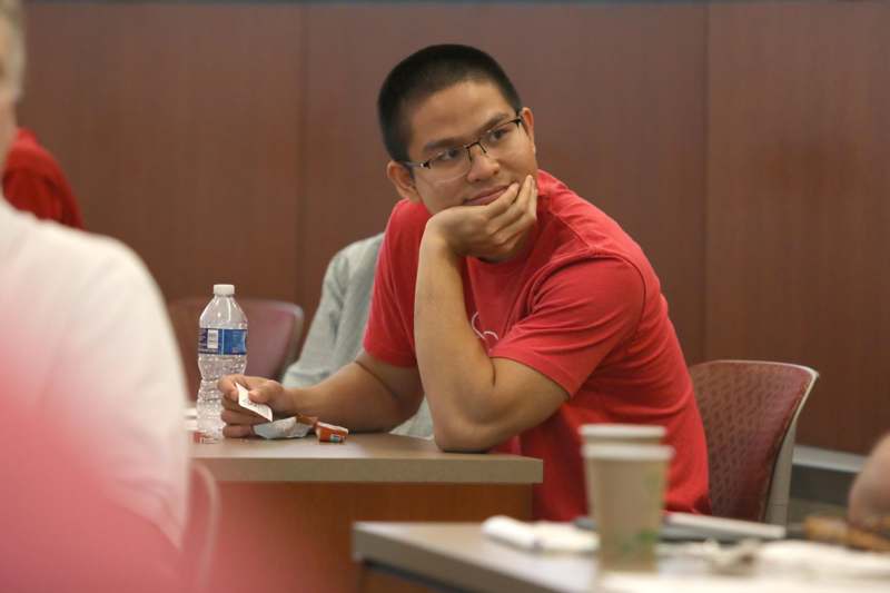 a man sitting at a table with his hand on his chin