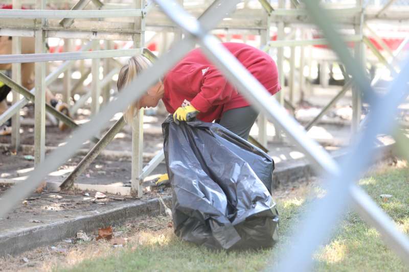 a woman picking up a black bag