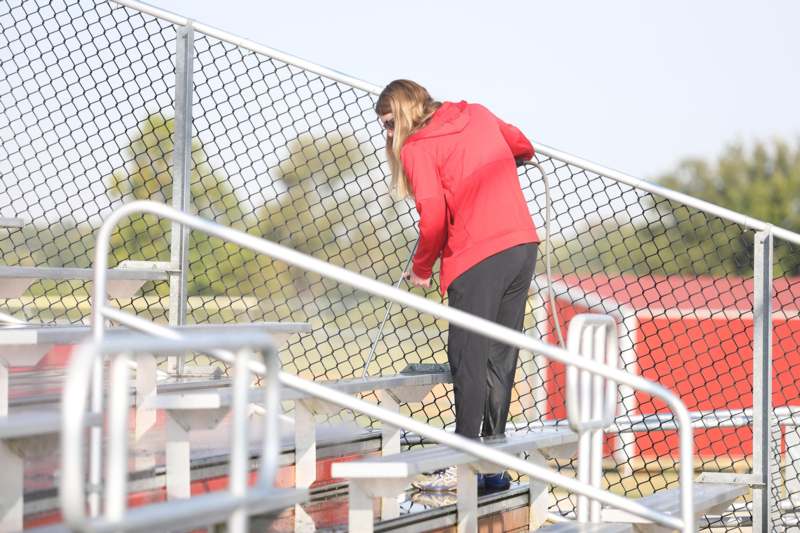 a woman standing on bleachers