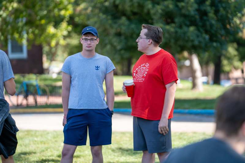 two men standing in a park