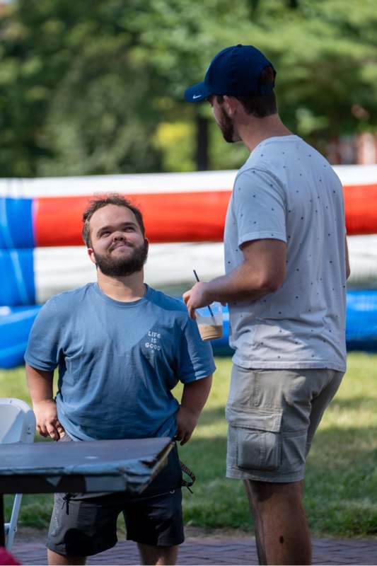 a man standing next to another man
