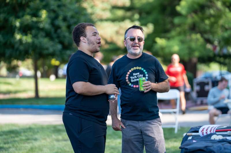 two men standing outside in a park