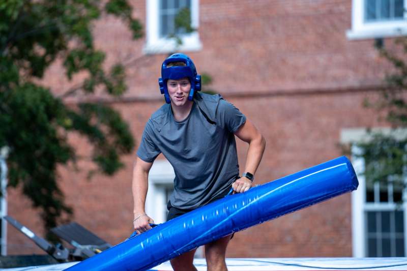 a man wearing a helmet and holding a large blue object