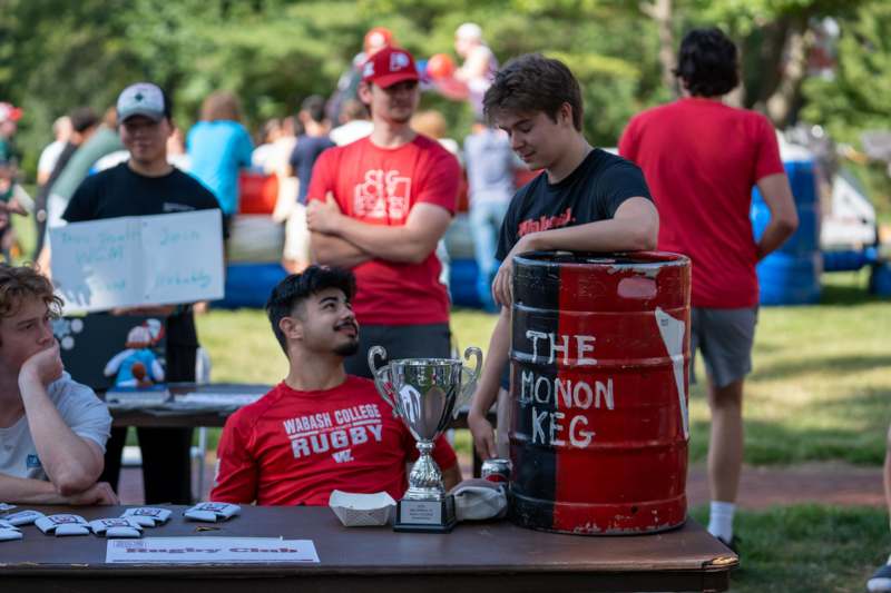 a group of people standing around a table with a trophy