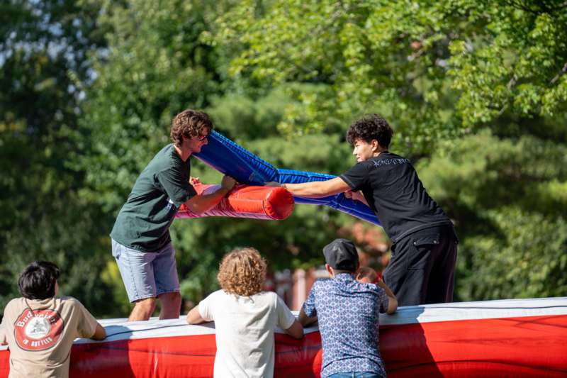 a group of people holding up two inflatable tubes