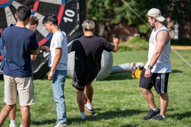 a group of men standing in a grass field