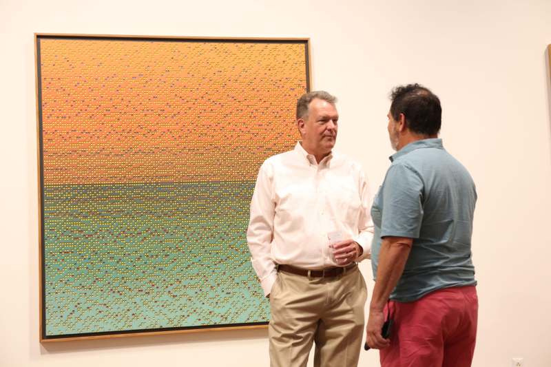 a group of men standing in front of a painting