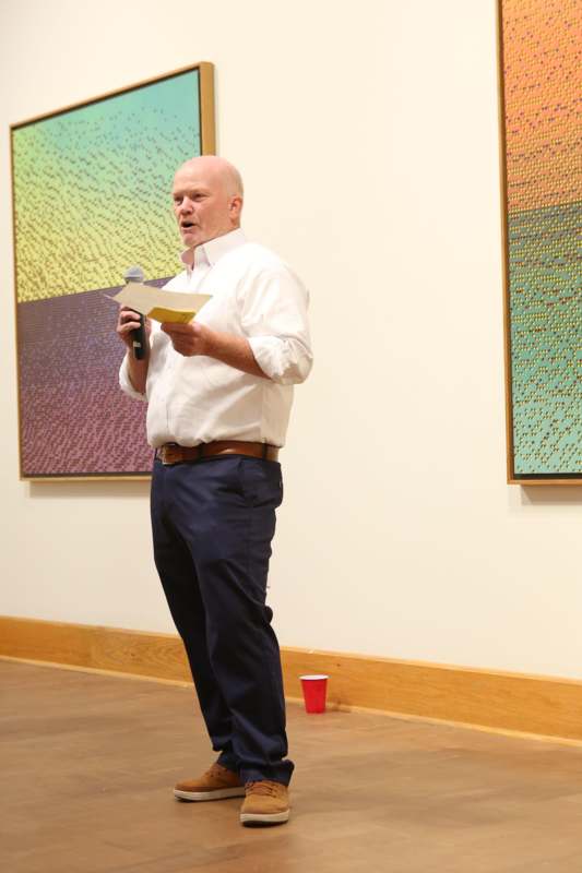 a man standing in front of a painting