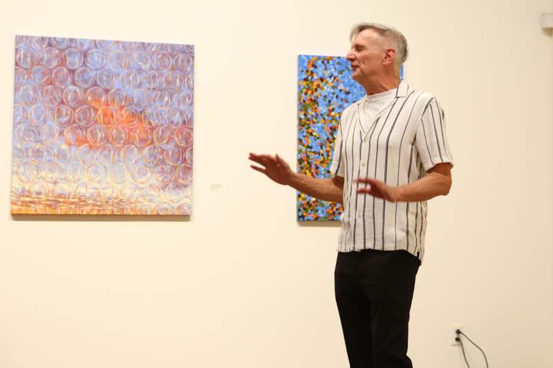 a man standing in front of a painting
