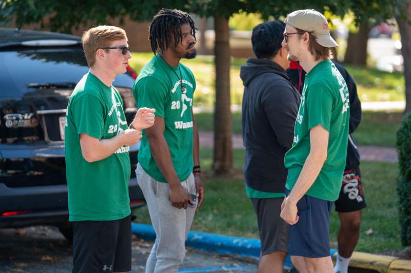 a group of men in green shirts