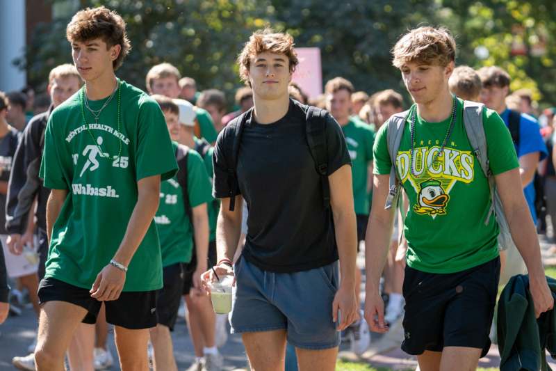 a group of men walking on a sidewalk