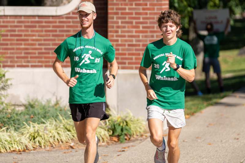 two men running on a sidewalk