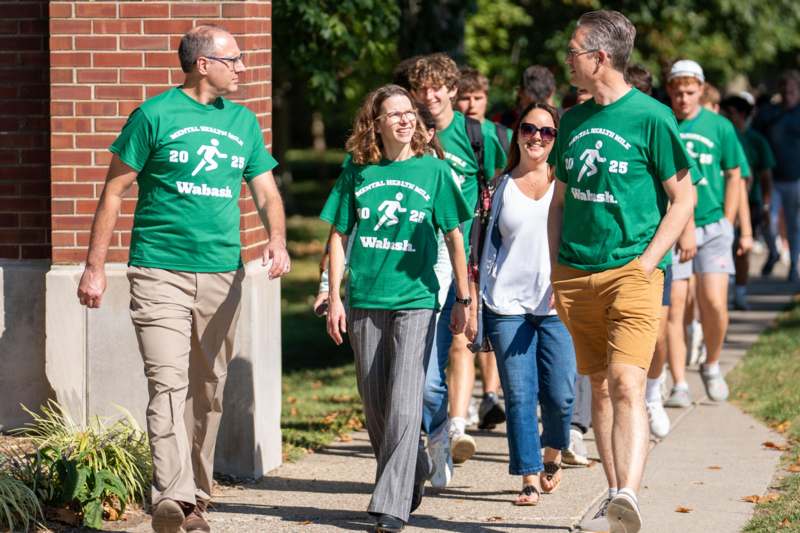 a group of people walking on a sidewalk